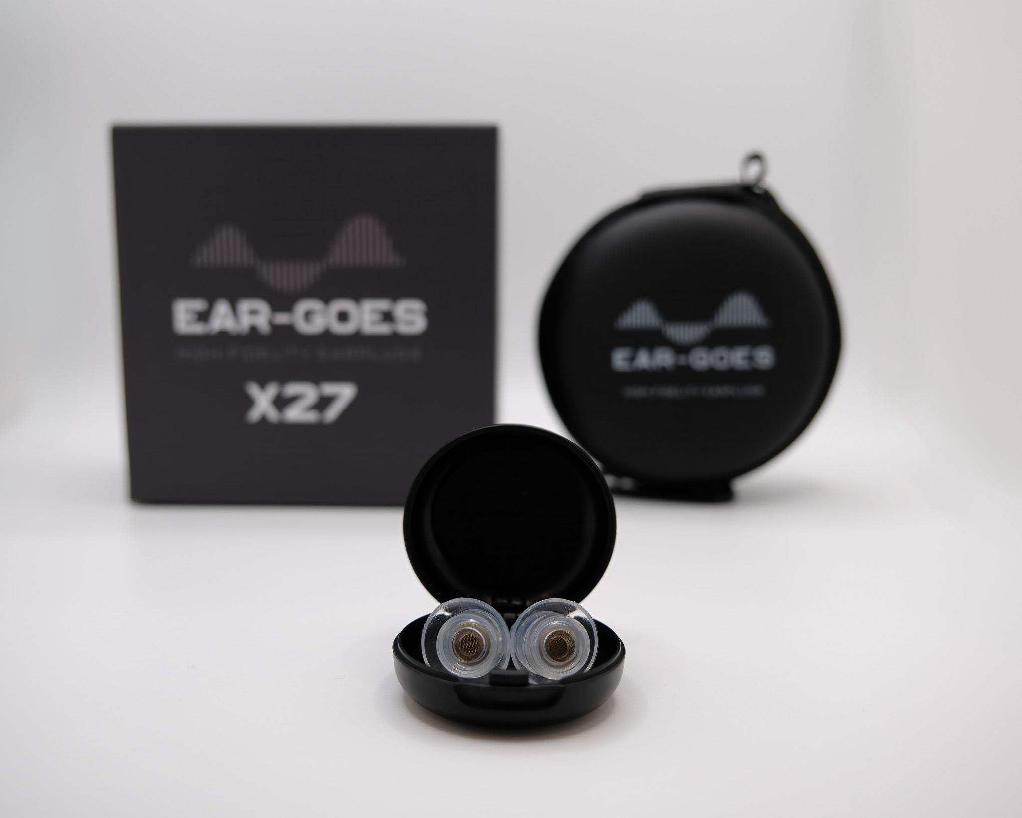 Ear-Goes X27 earplugs in open black case with a black box and round case in the background
